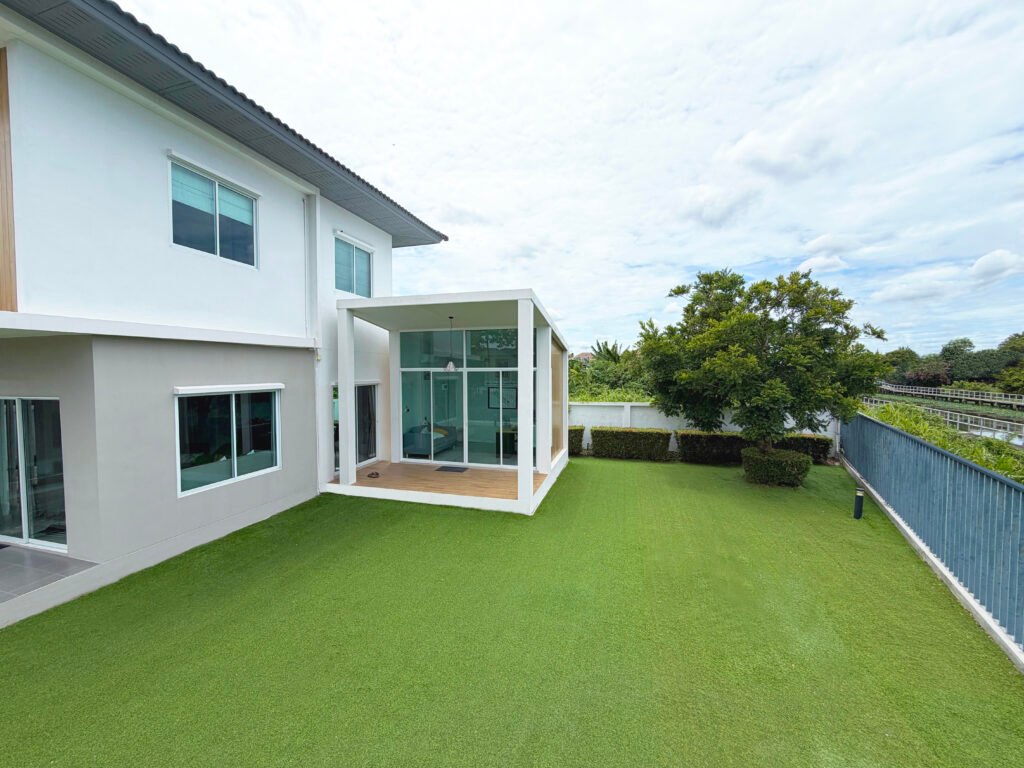 บ้านเดี่ยว 2 ชั้นสไตล์โมเดิร์น พร้อมสนามหญ้าหลังบ้านและห้องกระจกต่อเติม